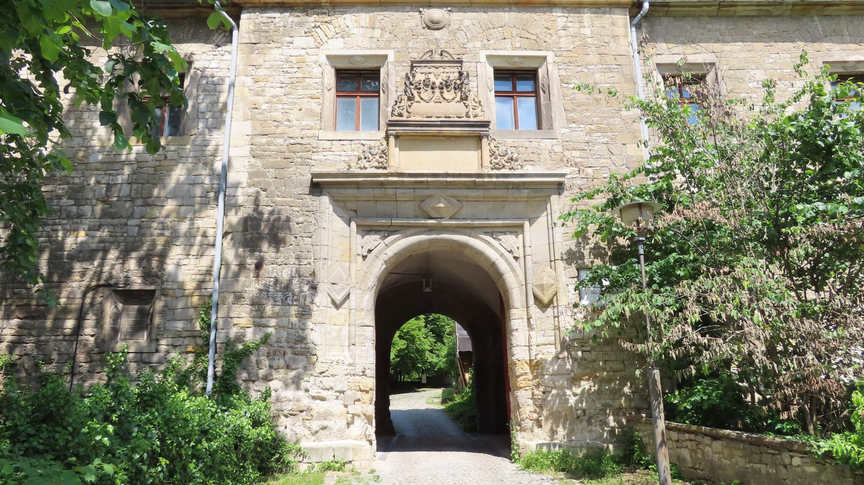 Eingang mit Wappen und Spruch am Schloss Beichlingen an der Schmücke in Thüringen.