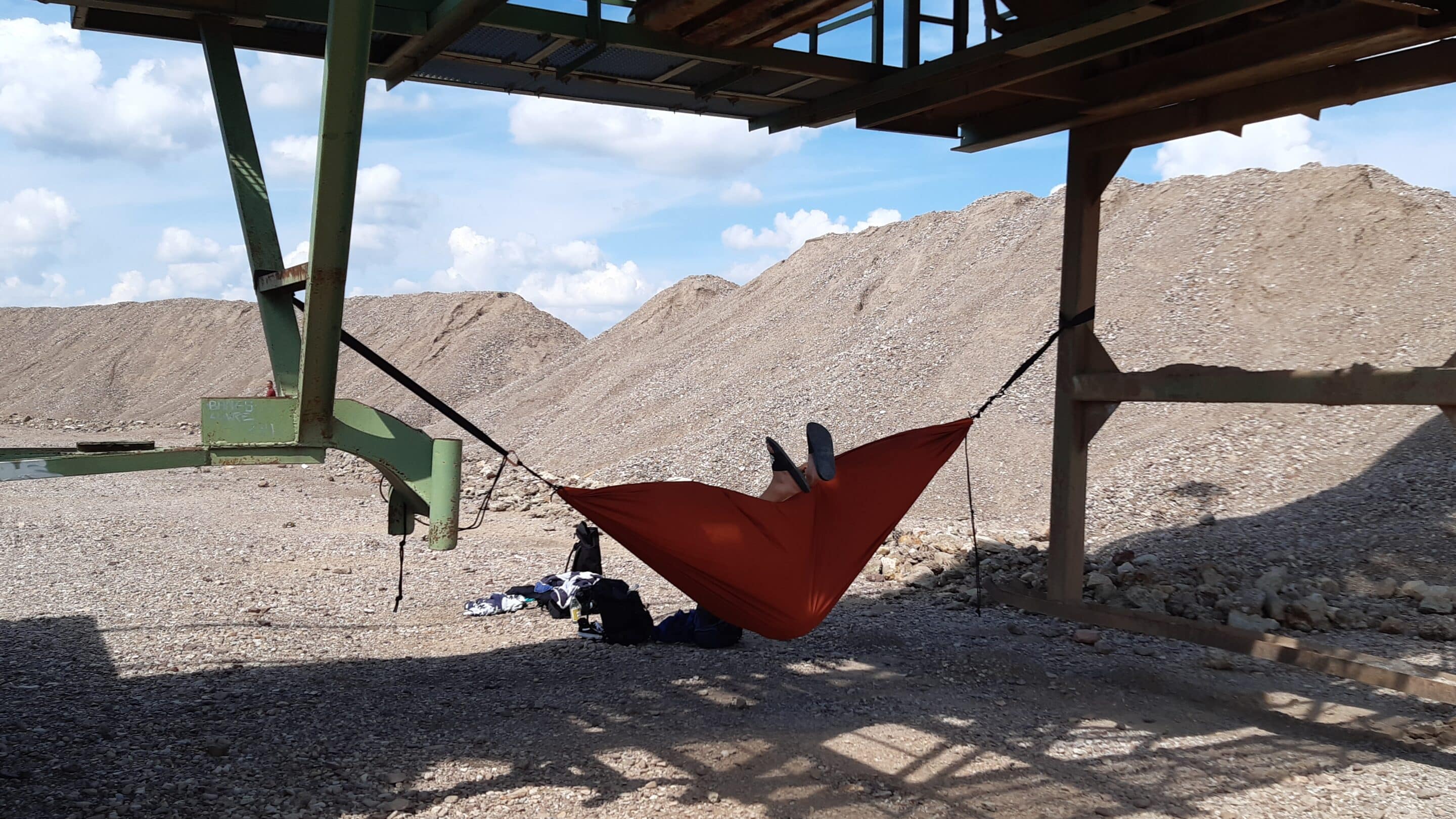 Wild swimming at Lake Sulzer Erfurt with a hammock under a gravel mining machine.