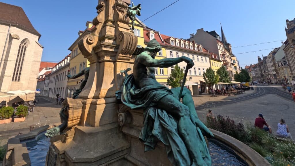 Bronzefigur am Alten Angerbrunnen auf dem Anger in Erfurt unter blauem Himmel