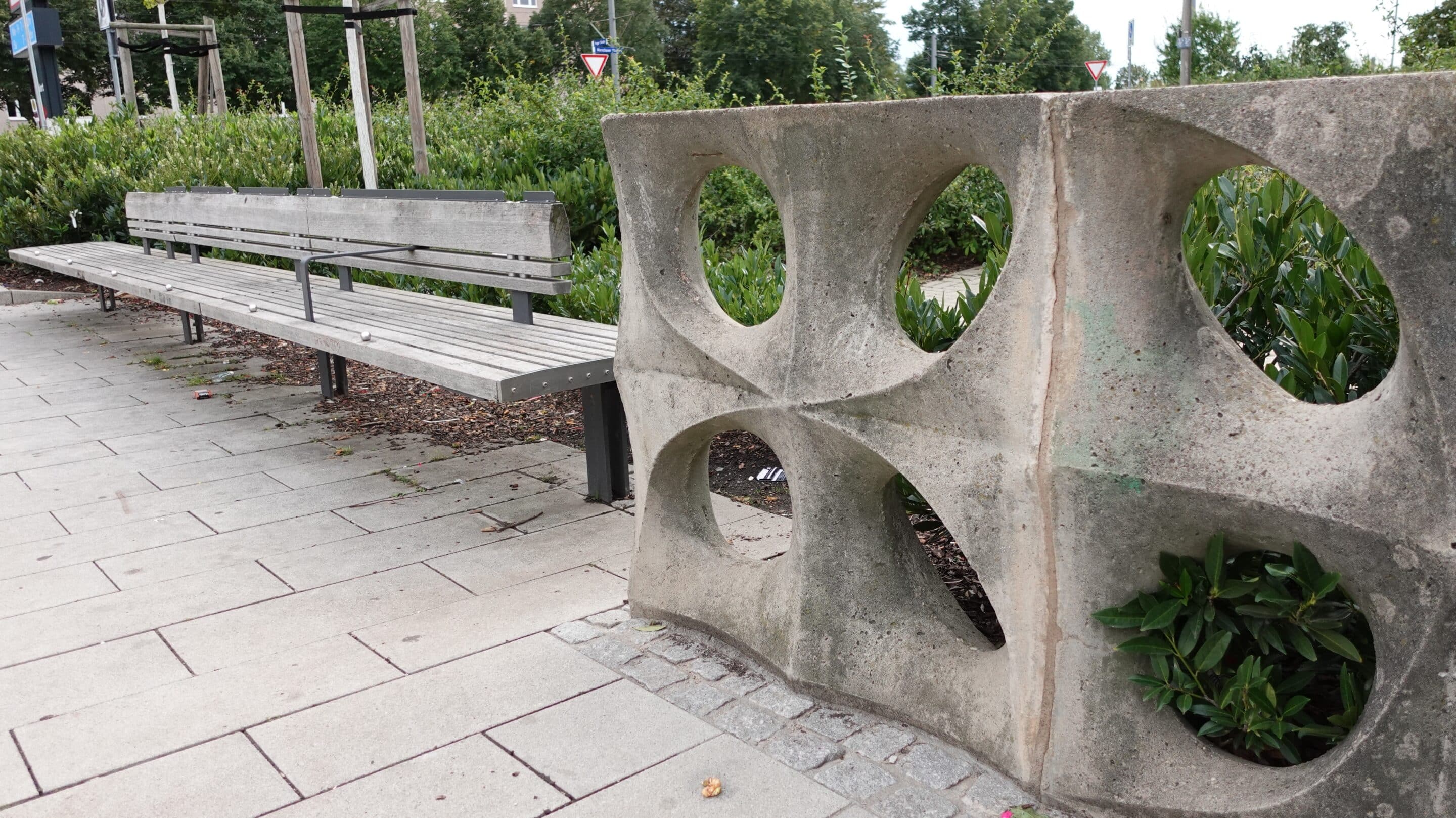 Eine moderne Bank steht neben einem Betonzaun aus DDR Produktion am Berliner Platz in Erfurt.