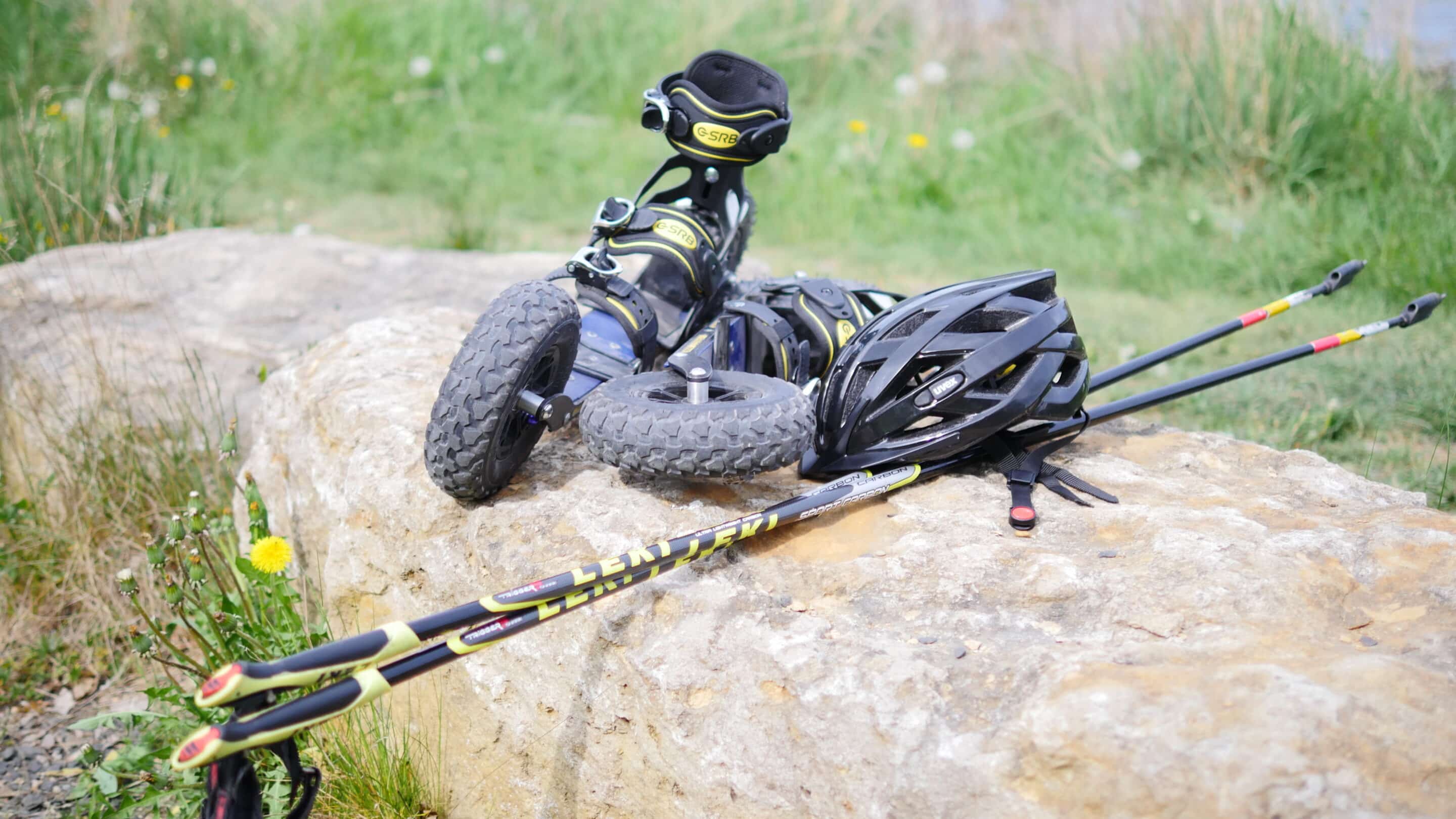 Eine Cross Skate Ausrüstung mit Rollern Stöcken und Helm.